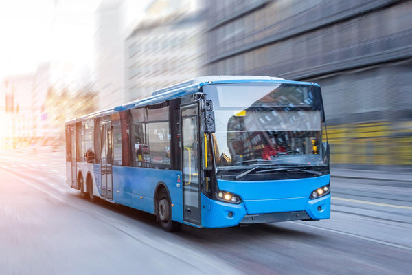 Blue bus moving on the road in city